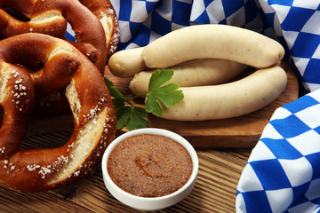 Bavarian veal sausage breakfast with sausages, soft pretzel and mild mustard on wooden board from...