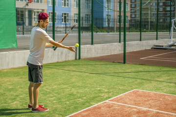 portrait of young male tennis player on  court on a sunny day