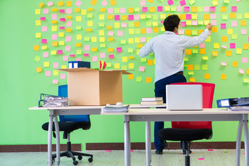 Man collecting his stuff after redundancy in the office with man