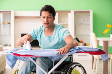 Disabled man on wheelchair ironing clothing