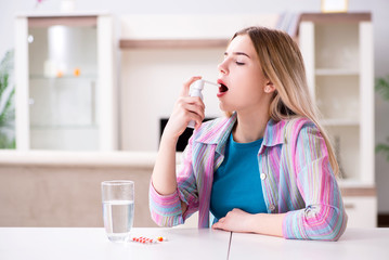 Young woman using inhalator to cope with asthma