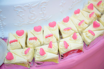 Many pieces of white cake and decorate by pink chocolate heart shape in buffet line. sweets and dessert bakery. valentine sweety concept. image for background, wallpaper, copy space and decoration.
