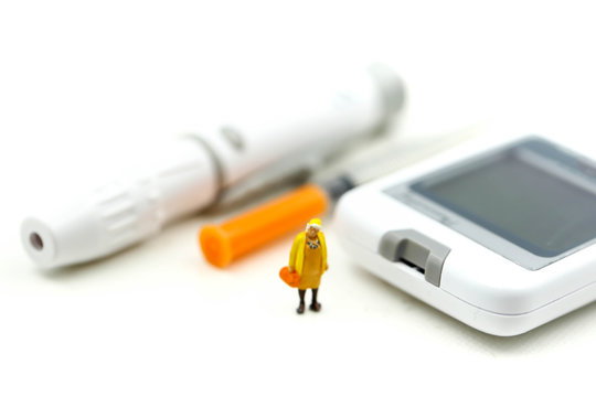 Miniature people : Doctor and patient with Glucose meter diabetes test and Syringe with measuring tape,concept of diabetes, healthy lifestyles and nutrition