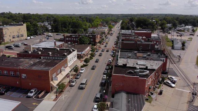 A slowly rising reverse aerial establishing wide shot of the small town of Bedford, Ohio on a late summer day.  	