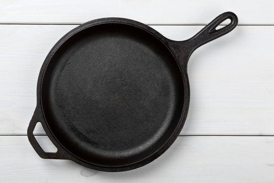 Empty, Clean Black Cast Iron Pan Or Dutch Oven Top View From Above On White Table