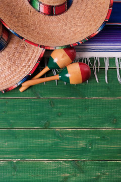 Mexico cinco de mayo fiesta carnival traditional green wood background border mexican sombrero maracas serape rug or blanket photo