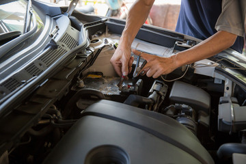 Engine engineer is replacing car battery because car battery is depleted. Concept car maintenance 