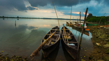 Fishing Boats Standing Near Riverside At Evening Sunset