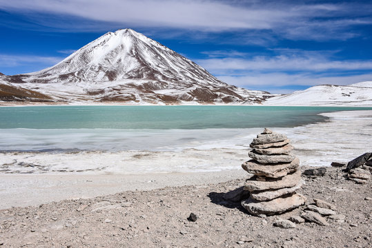 A rock pile stands in front of Laguna Verde and the Licancabur Volcano, Reserva Eduardo Avaroa, Sud Lipez province, Bolivia