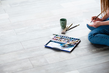 creative leisure. painting hobby. artful personality. talented artist drawing sitting on the floor.