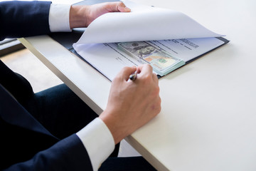 anti bribery and corruption concepts, money offered in file, giving money in file while making deal to agreement