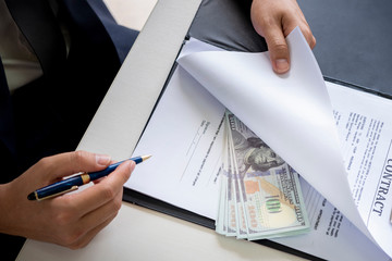 anti bribery and corruption concepts, money offered in file, giving money in file while making deal to agreement