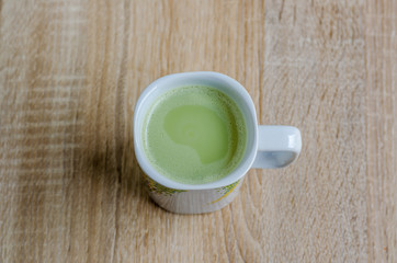 Obraz na płótnie Canvas cup of green tea matcha latte on wooden background