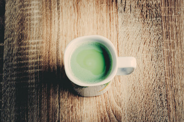 cup of green tea matcha latte on wooden background