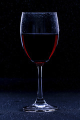 Low key glass of red wine with a dewdrop // still life