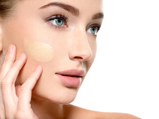 Young woman with cosmetic foundation on skin.
