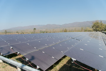 View of solar farm in sunlight with blue sky, dirty solar cell  array, green energy concept.