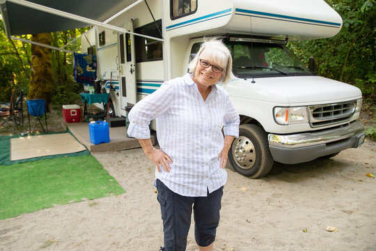 Happy mature woman with white hair camping with RV