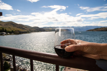 Glass of red wine at a lake