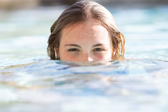 Girl with mouth and nose under water in swimming pool