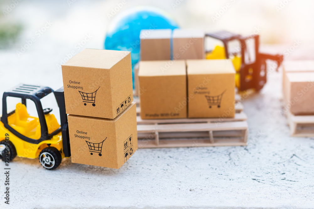 Wall mural close up mini forklift truck load stack of cardboard box with shopping cart symbol on pallet and glo