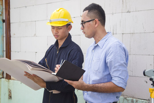 Asian Inspector Checking Structure Of New Property And Taking Note In The Clipboard For Review And Fix The House Before Sell To Client.