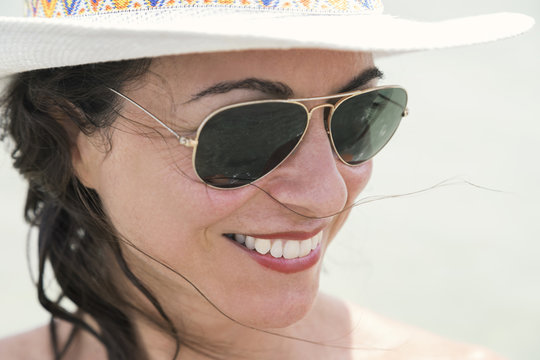 Volto di donna con cappello e cocchiali da sole