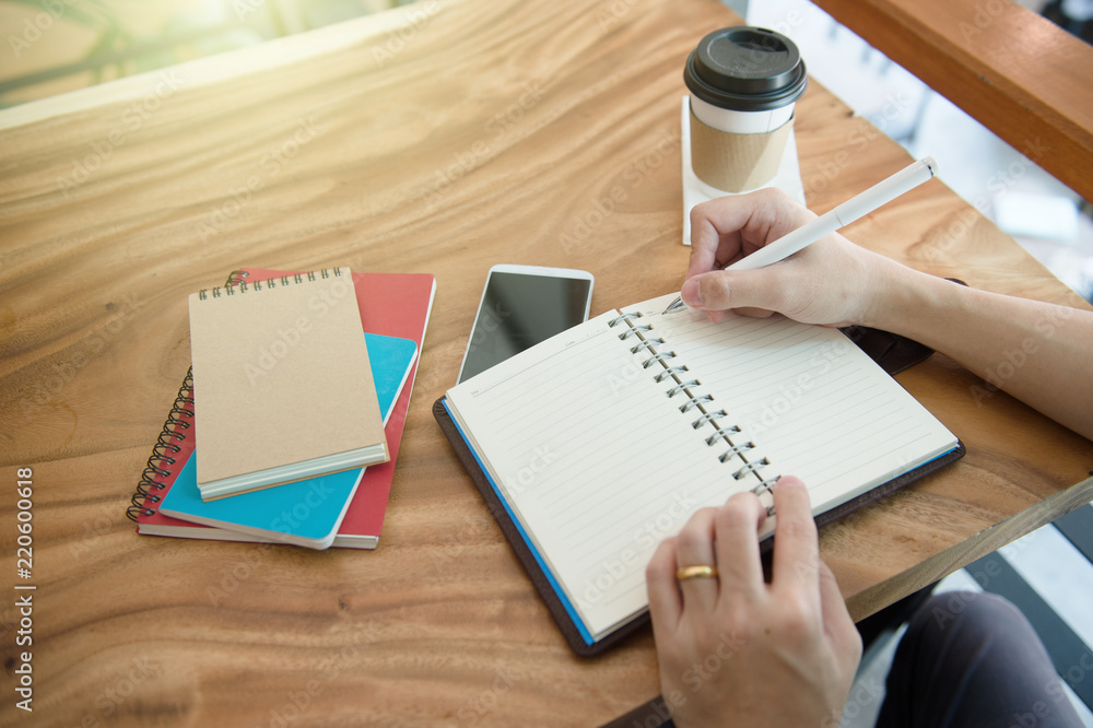 Wall mural businessman working on a desk. freelance work at home office. writing note on a book. urgent agenda.