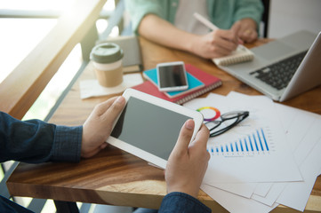 business team  briefing marketing strategy with smart phone, tablet, notebook, and laptop on wooden desk with,Freelance work at home office. Writing note on a book.