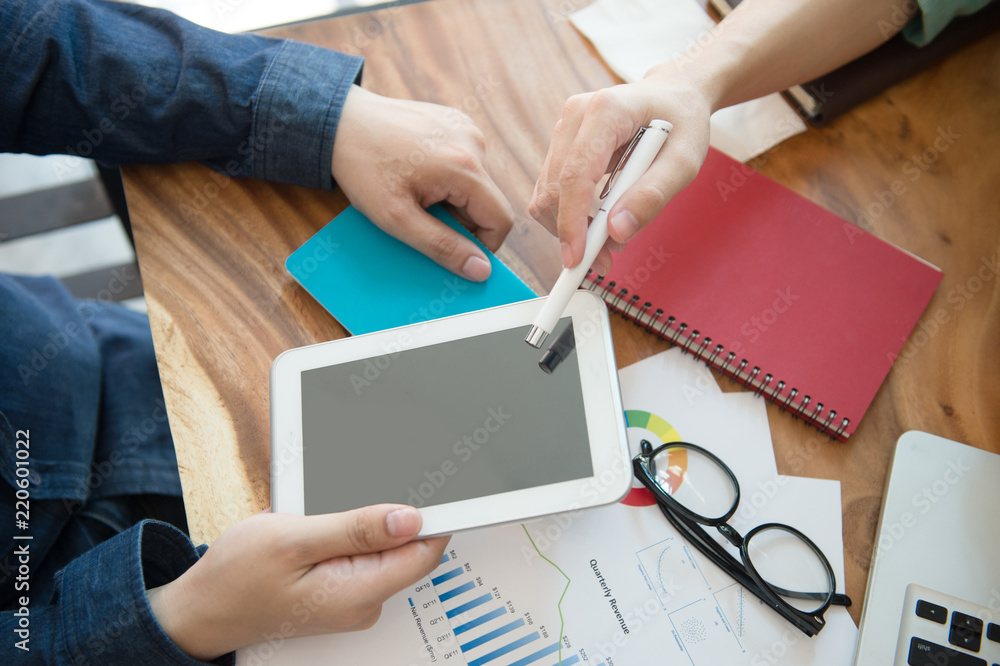 Wall mural business team analysing marketing strategy with smart phone, tablet, notebook, and laptop on wooden 