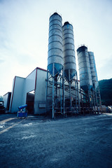 Exterior view of a cement factory. Concrete mixing silo, construction site facilities © lzf