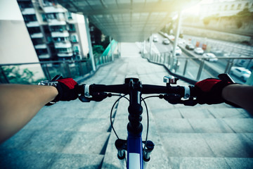 Riding bike down ramp of overpass in city