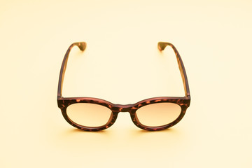 A pair of tortoises shell style fashion glasses isolated on light color background.