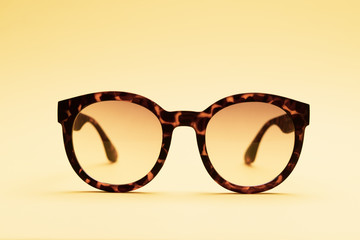 A pair of tortoises shell style fashion glasses isolated on light color background.