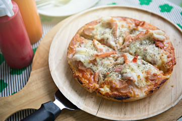Close up seafood pizza that combined with shrimp crap and squid on wooden plate and pizza paddle