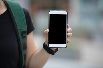 Woman hands using smartphone at city street side,checking the ride-hailing apps