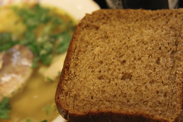 Fish soup in the white bowl with herbs and spoon