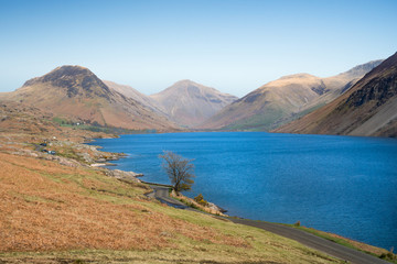 Street leading along a blue lake, with highlands in the background. Wast Water, Cumbria, England