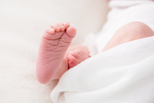 Close-up of foot of newborn baby on white background