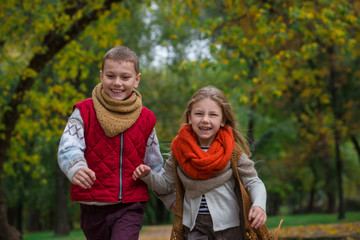 Fototapeta premium Happy children play and run in autumn park