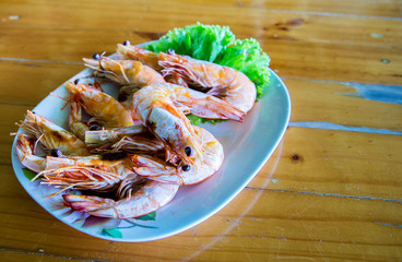 Grilled prawns on the blue dish, placed on the wood table. seafood menu. sea arthropod for food. local food recommended for tourist and traveler. image for menu list, objects