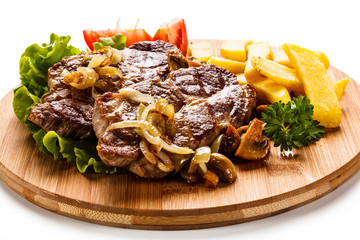 Grilled steak with french fries and vegetables on white background