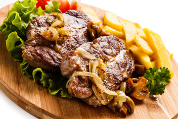 Grilled steak with french fries and vegetables on white background
