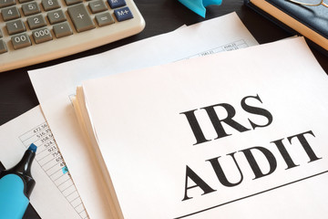 IRS Audit report and calculator on a desk.