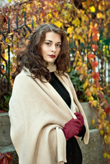 woman in a  coat walks in autumn park