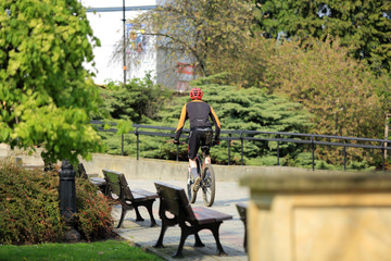 Brudny rowerzysta jedzie przez park w Opolu. - obrazy, fototapety, plakaty