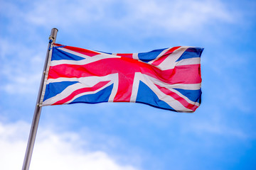 The British flag flutters against the blue sky 