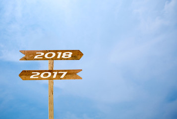 Sign banner 2017, 2018  blue sky background. two way Wooden sign isolated on sky.