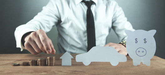 Businessman stacking coins. Concept of saving money for house and car.