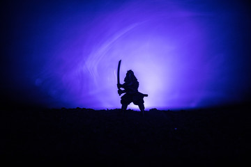 Obraz na płótnie Canvas Fighter with a sword silhouette a sky ninja. Samurai on top of mountain with dark toned foggy background.